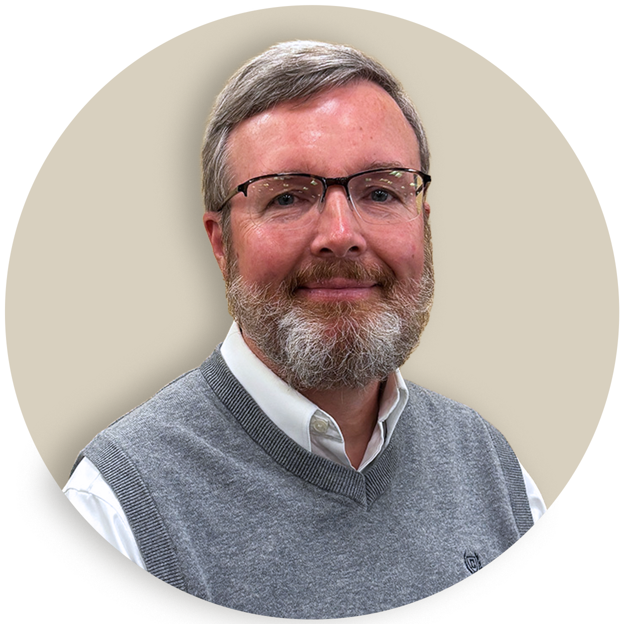 Portrait of Brian Messner with glasses and a gray beard wearing a gray sweater vest over a white shirt