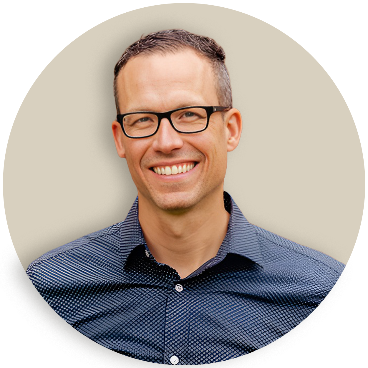 Portrait of Brian Talty wearing glasses and a blue patterned shirt