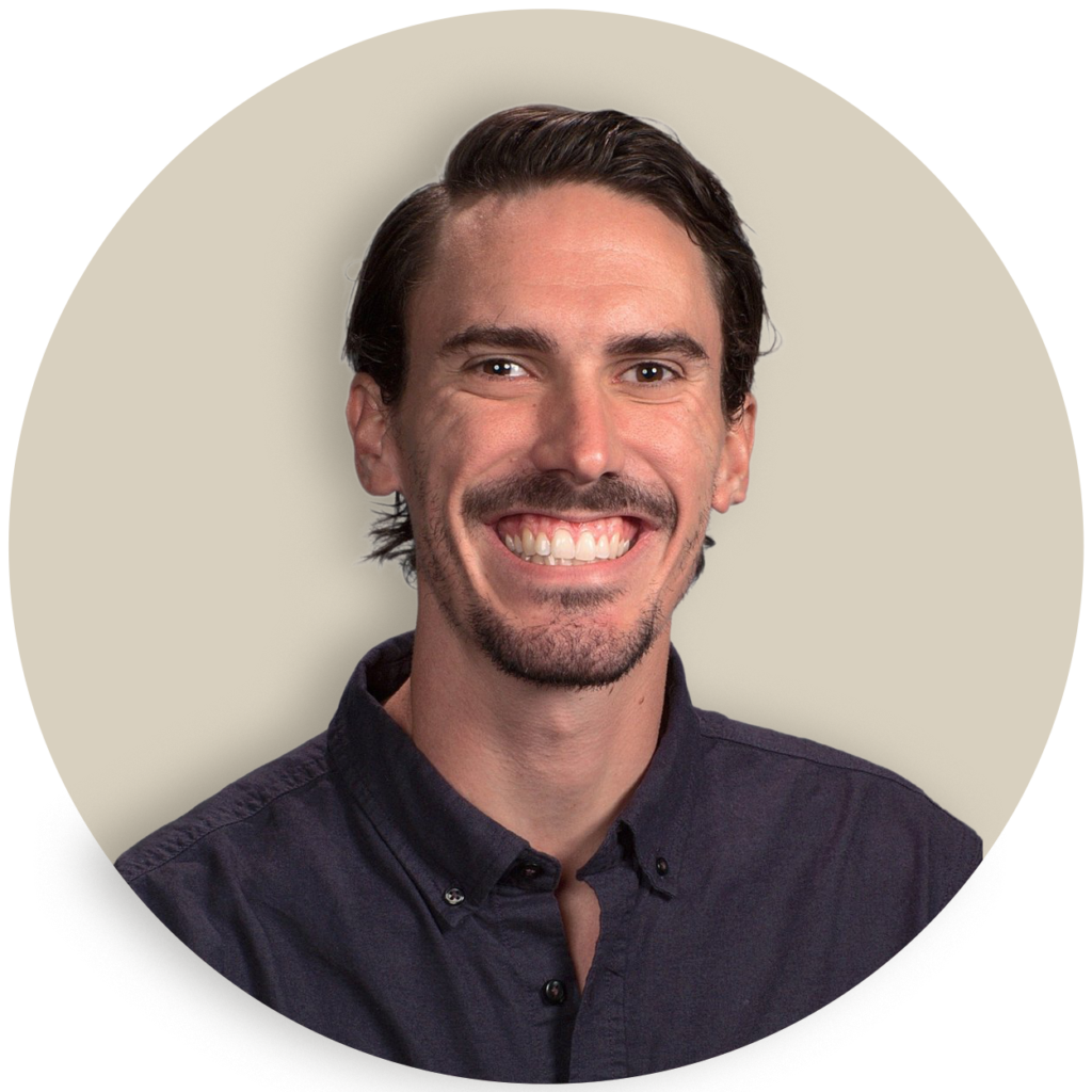 Portrait of Caleb Brown with dark hair and a mustache against a plain background