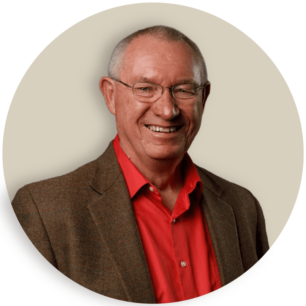 Portrait of Chuck Sackett wearing glasses, a red shirt, and a brown blazer