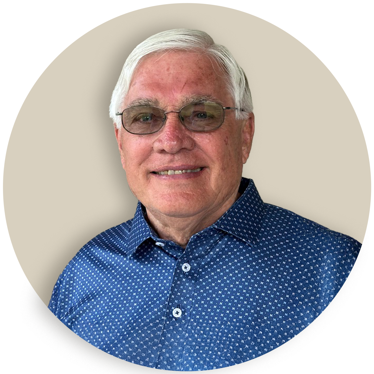 Portrait of Donnie Rowe with white hair and glasses wearing a blue patterned shirt