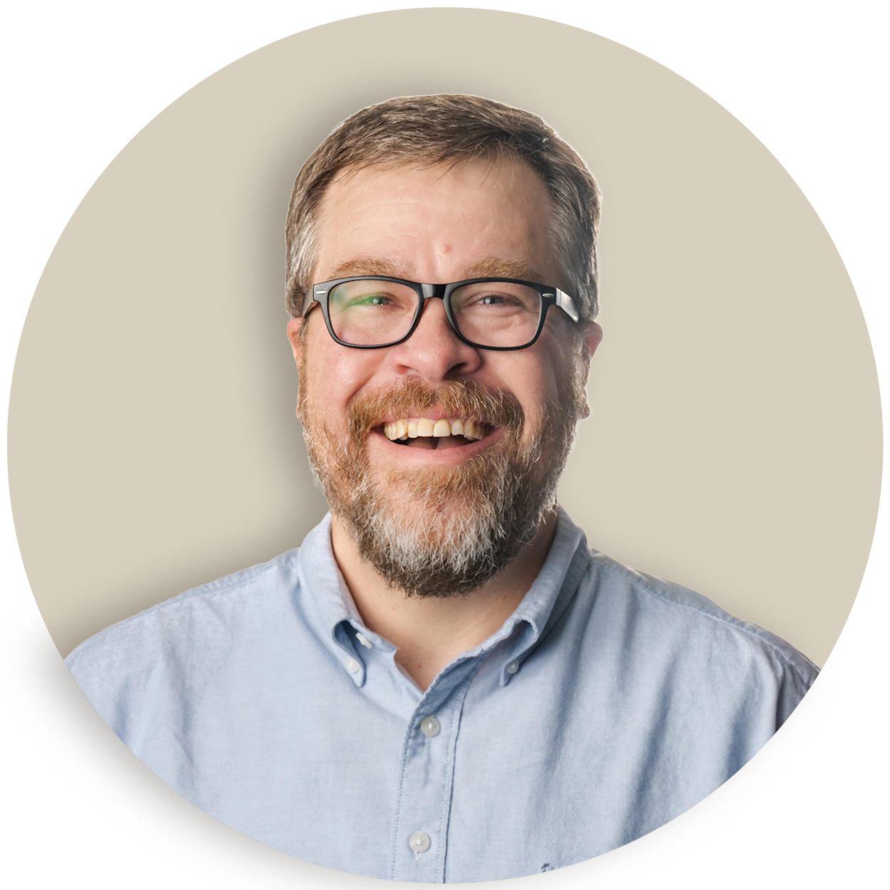 Doug Welch with glasses and a beard in a light blue shirt on a beige background