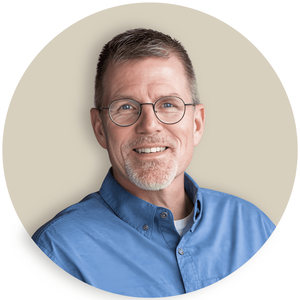 Portrait of Greg Taylor wearing glasses and a blue shirt
