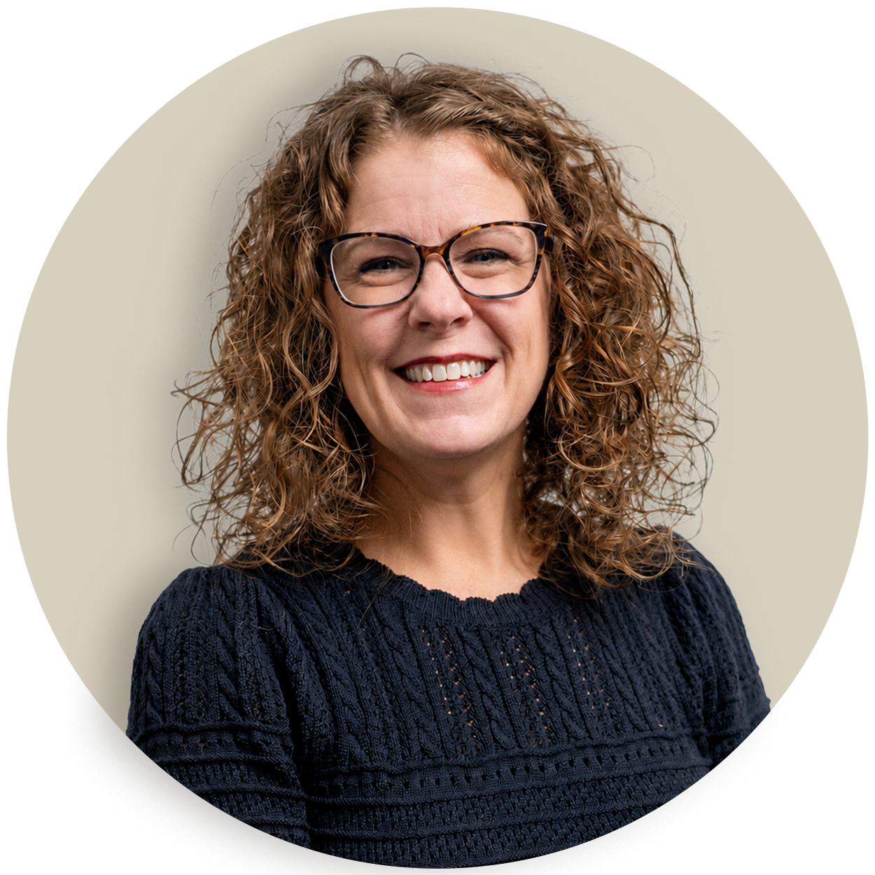 Portrait of Jill Dicken with curly hair and glasses, wearing a dark sweater