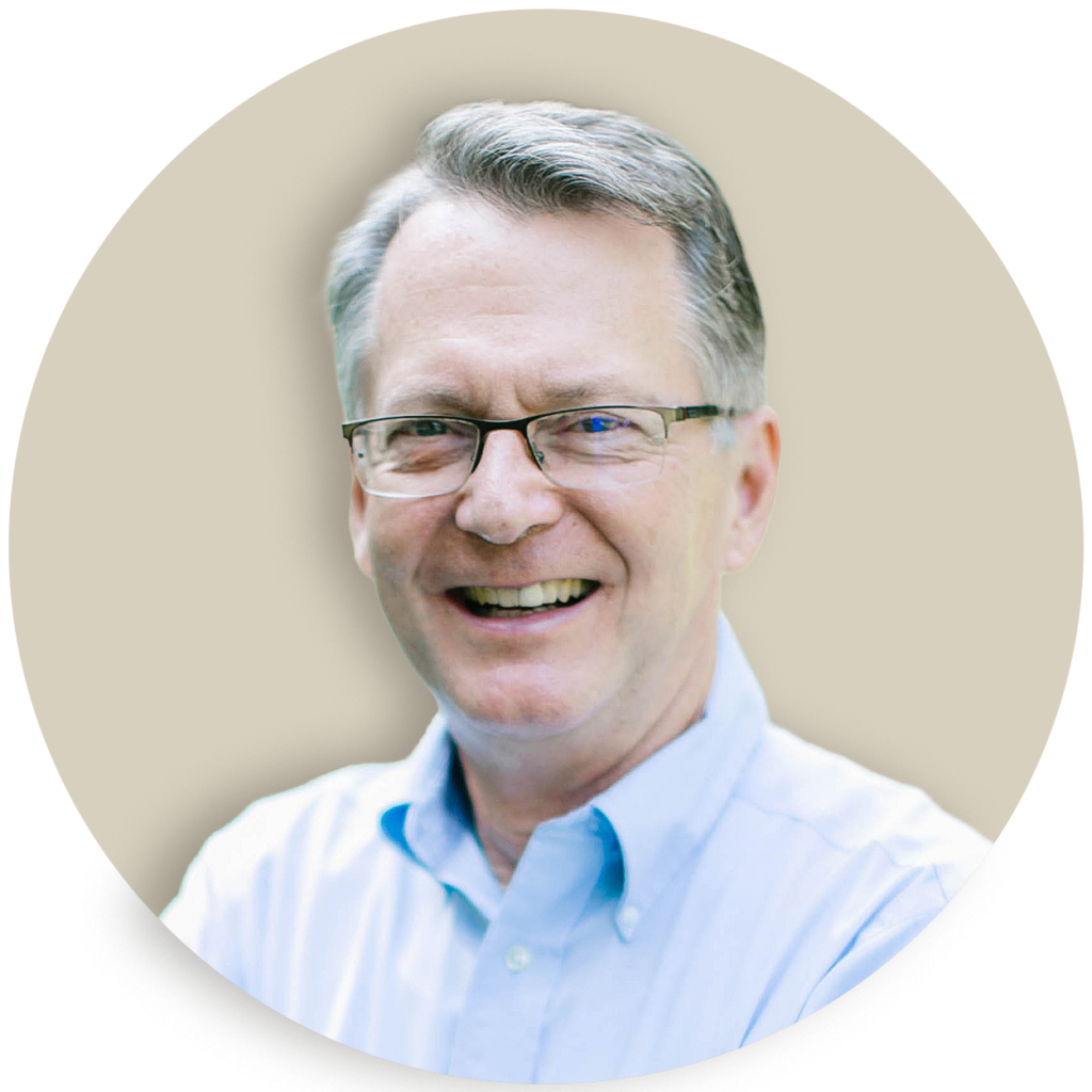 Portrait of Jon Weatherly wearing glasses and a light blue shirt