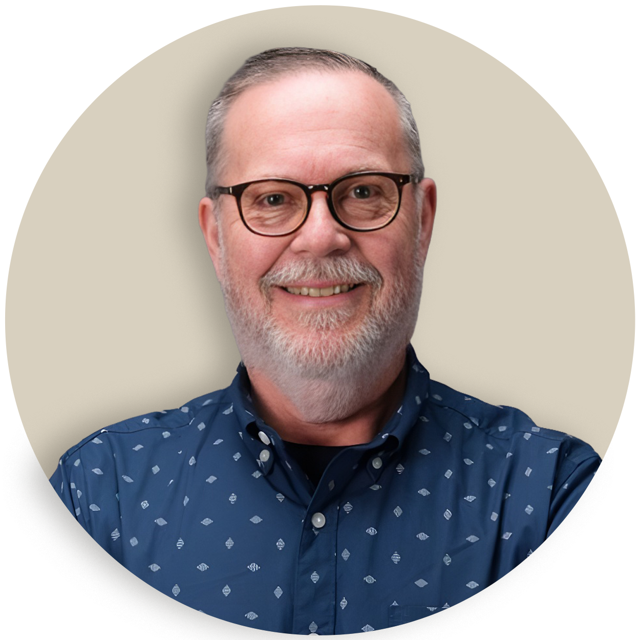 Portrait of Roger Clark with glasses and a gray beard wearing a blue patterned shirt