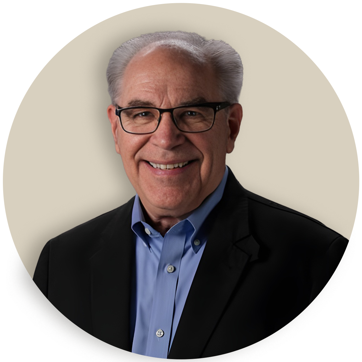 Portrait of Warren Knowles wearing glasses, a blue shirt, and a dark blazer, smiling against a plain background
